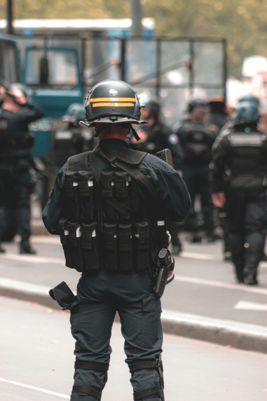 man in black police uniform walking on street during daytime