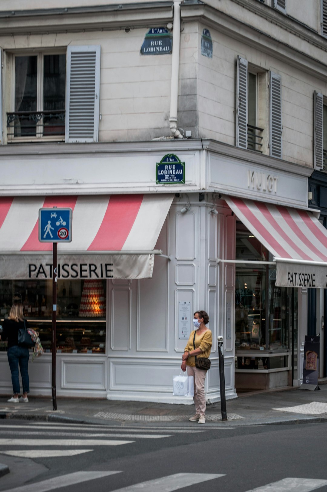 woman in brown coat standing in front of store during daytime