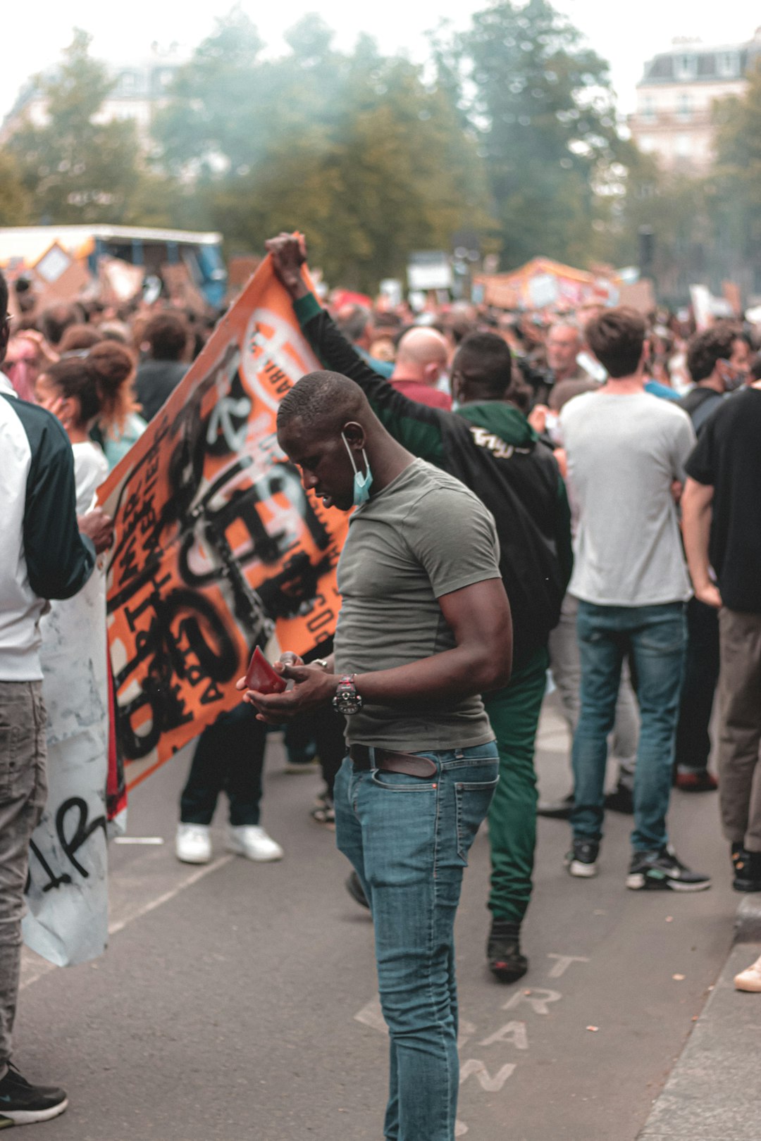 man in black t-shirt and blue denim jeans standing on street during daytime