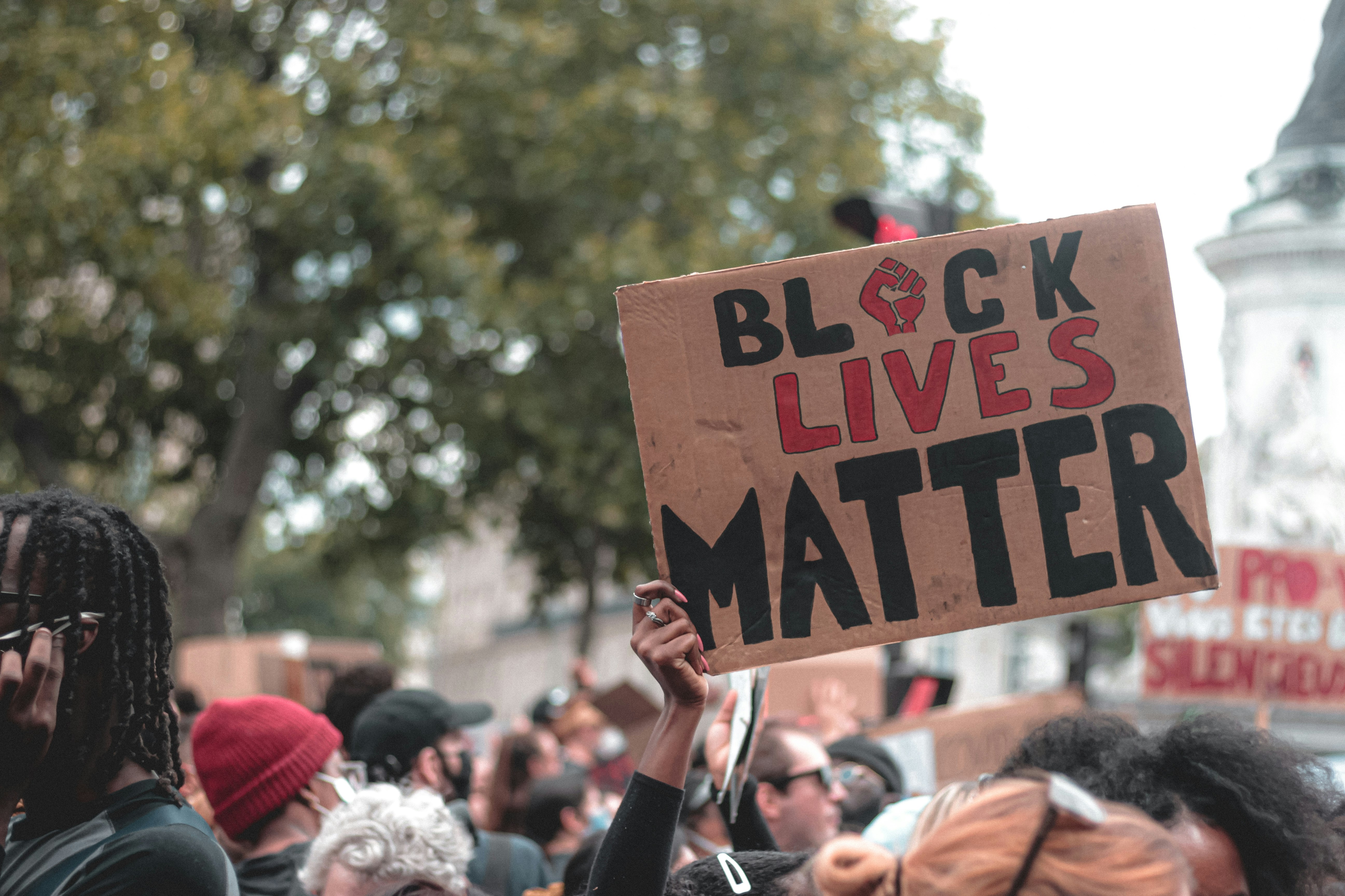 people holding brown wooden signage during daytime