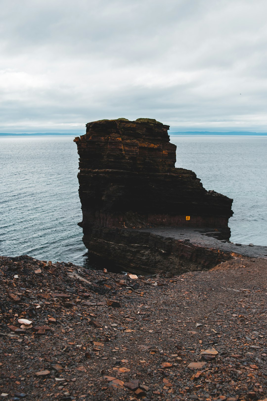 brown rock formation near body of water during daytime