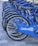 A row of blue bicycles is aligned on a tiled surface, each bicycle featuring the LinkedIn logo prominently displayed on the side panels. The bicycles are neatly arranged, suggesting they are part of a bike-sharing program or rental service.