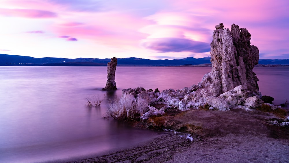 brown rock formation near body of water during daytime