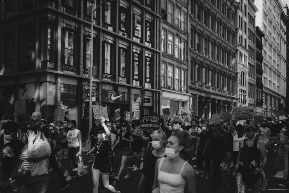 grayscale photo of people in front of building