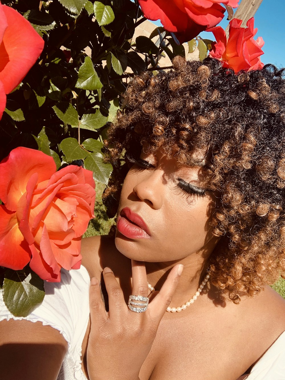 Femme en robe blanche avec coiffe de fleurs rouges et jaunes