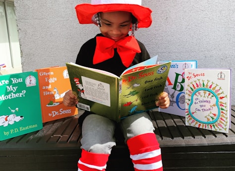 girl in red hat holding book