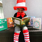 girl in red hat holding book