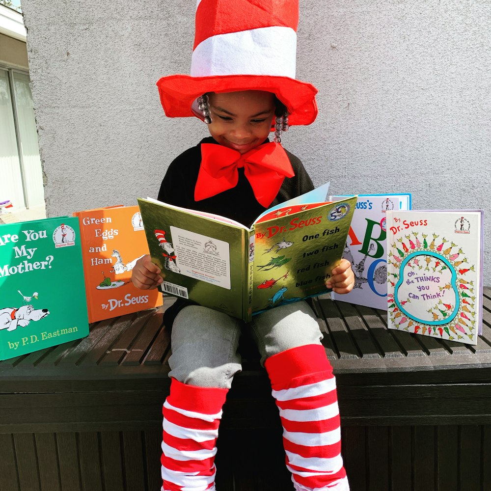 girl in red hat holding book