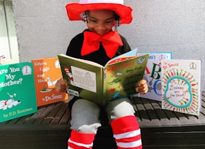 girl in red hat holding book