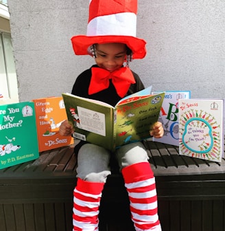 girl in red hat holding book