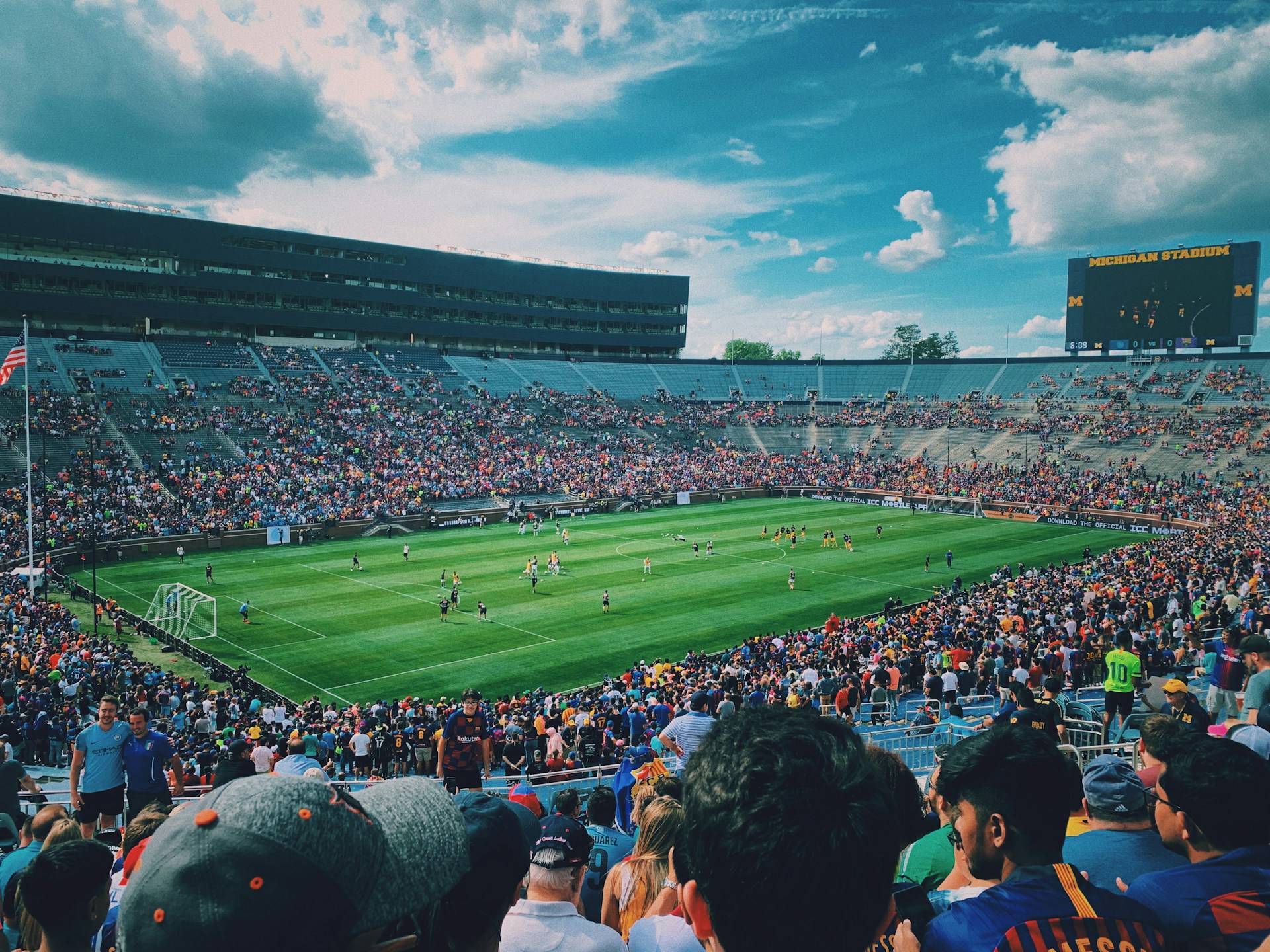 people watching football game during daytime