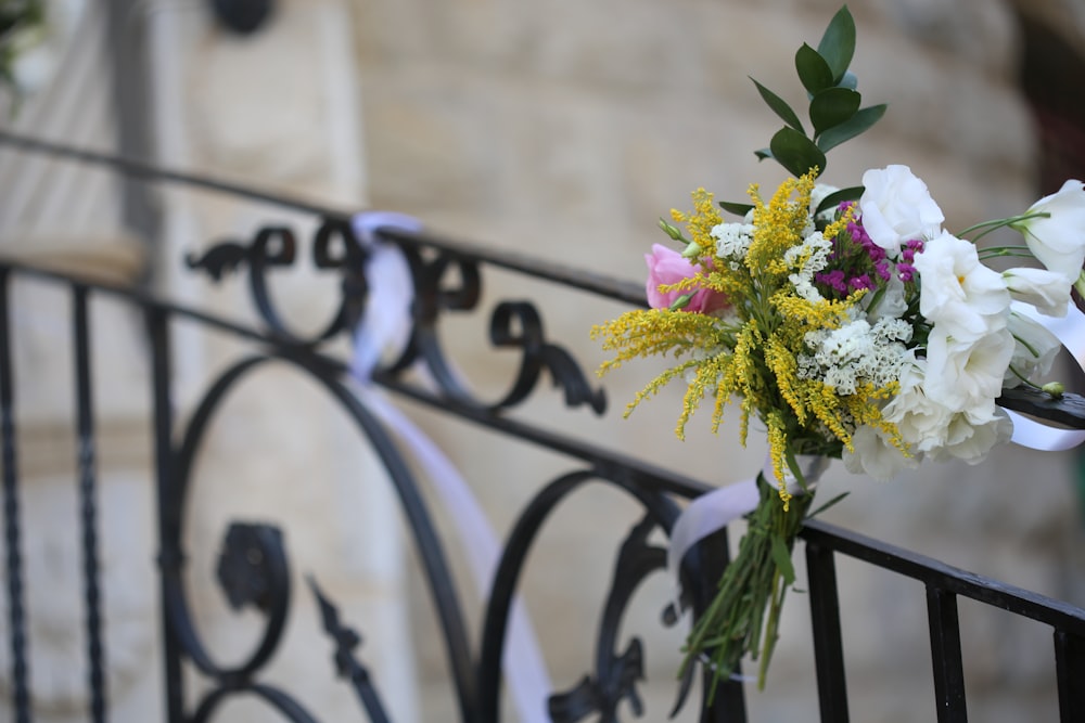 white and pink flowers on black metal fence