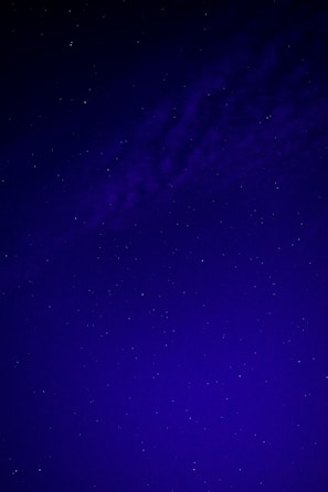 A dark blue night sky filled with bright white stars arranged in a subtle cross pattern.