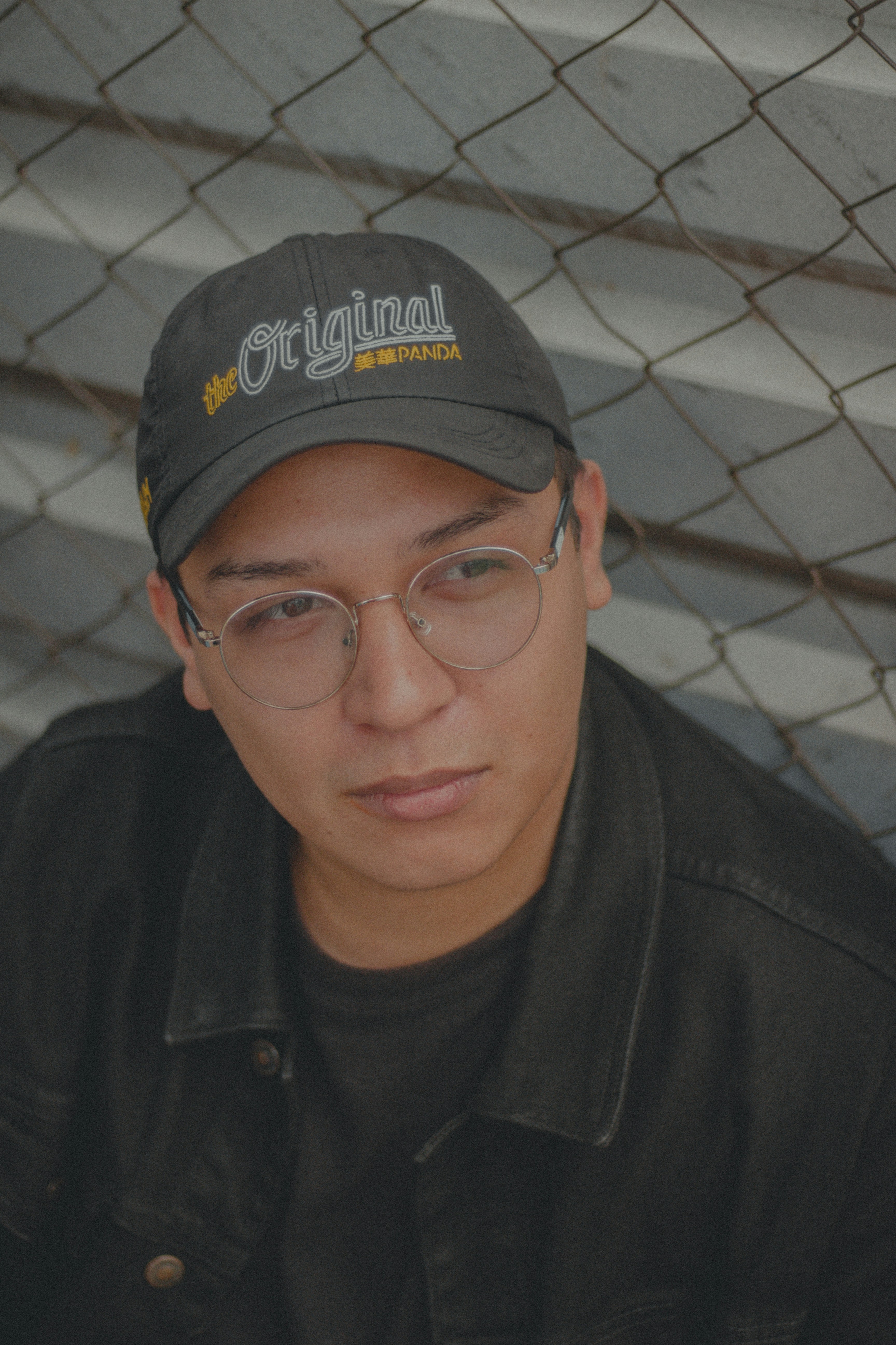 man in black crew neck shirt wearing blue cap and eyeglasses