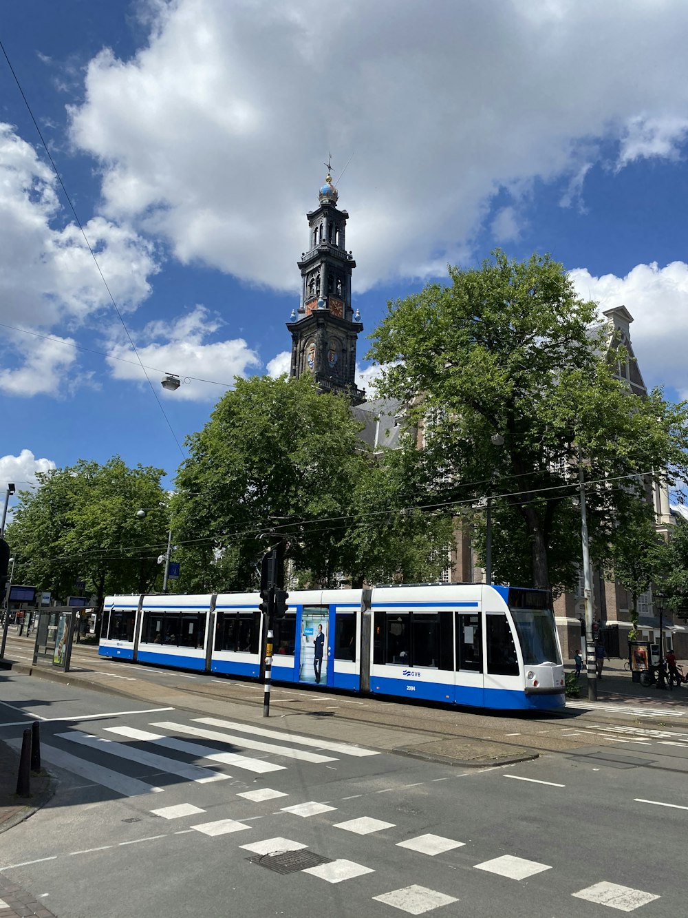 a blue and white train traveling past a tall building