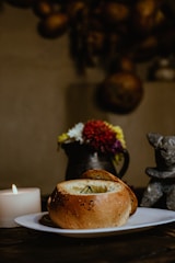 A rustic wooden table set with a steaming bowl of hearty stew and fresh bread, bathed in soft golden light.