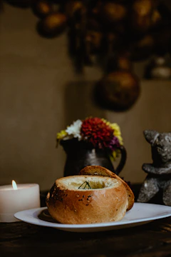 An intimate shot of a rustic wooden table set with a steaming bowl of soup and soft candlelight.
