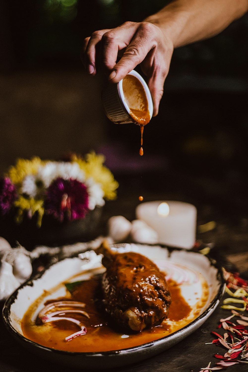 person pouring coffee on white ceramic plate