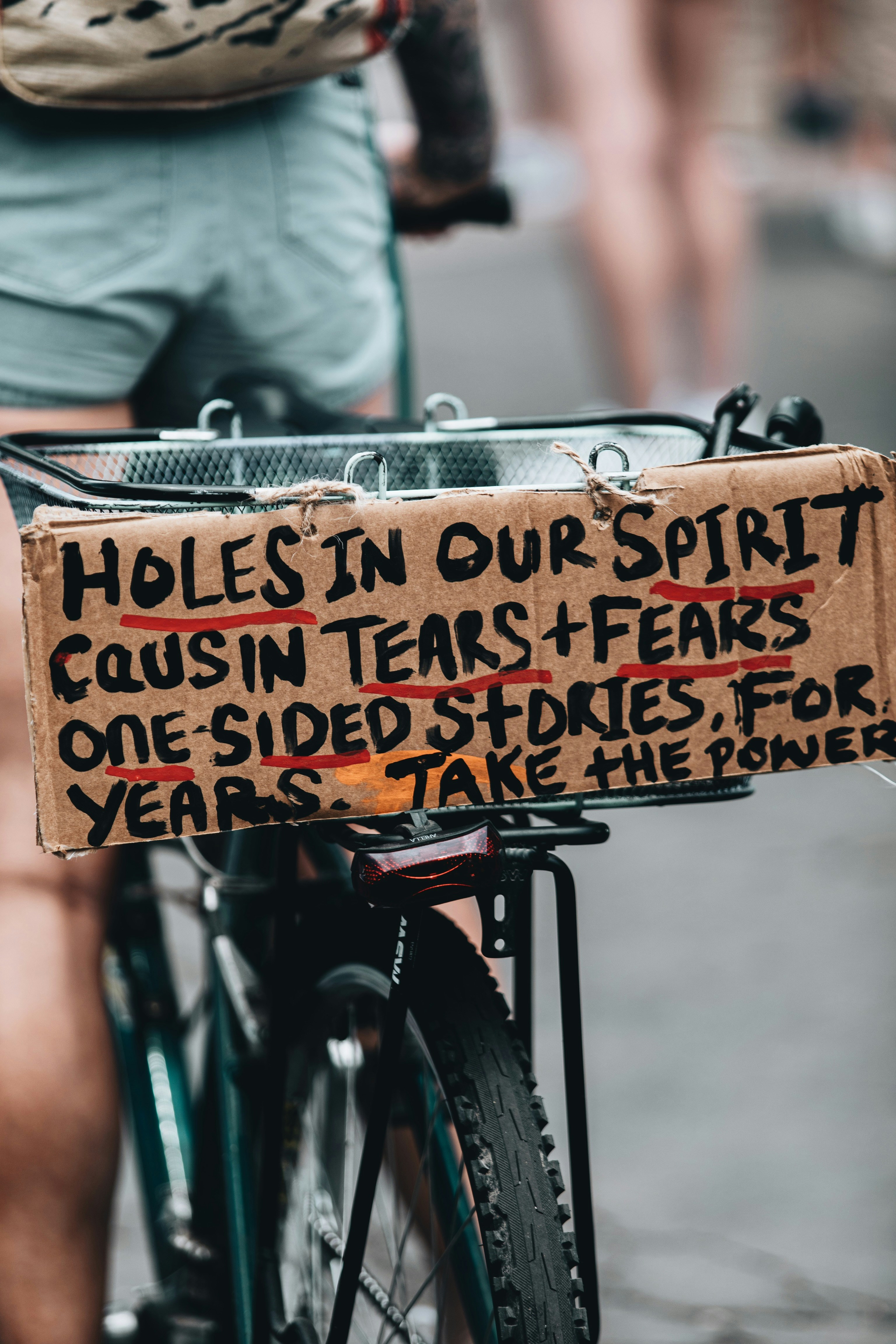 person holding brown wooden signage