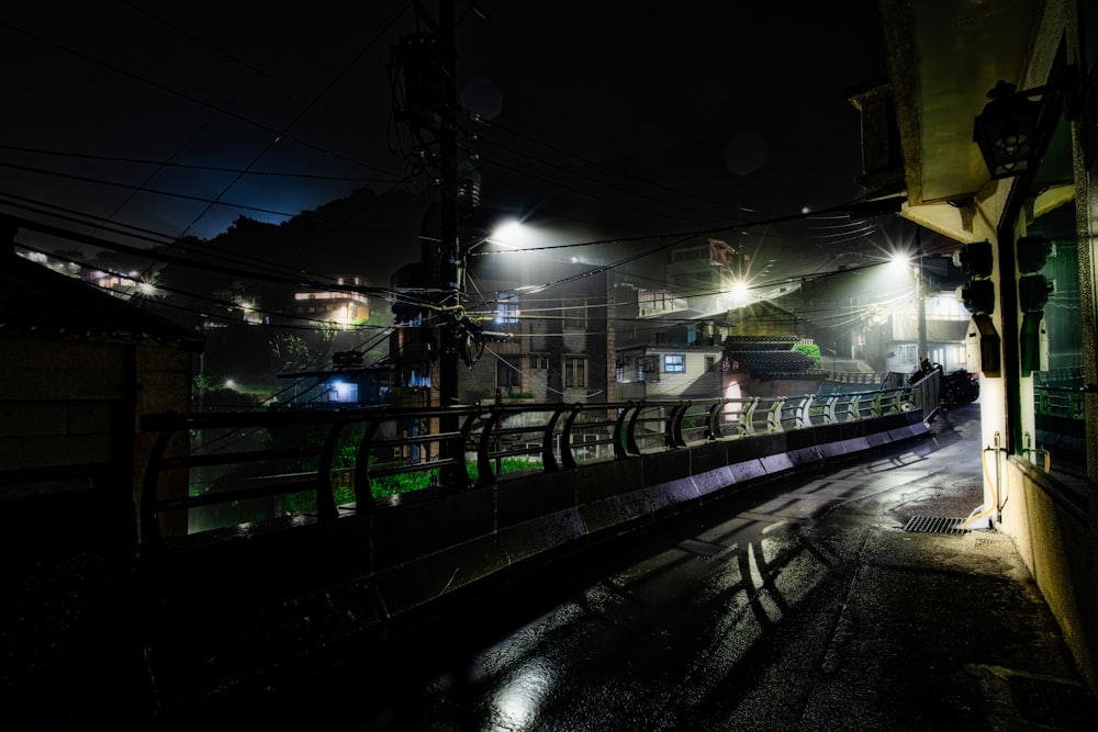 train rail near green metal fence during night time