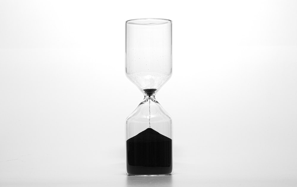 clear glass hour glass with black liquid