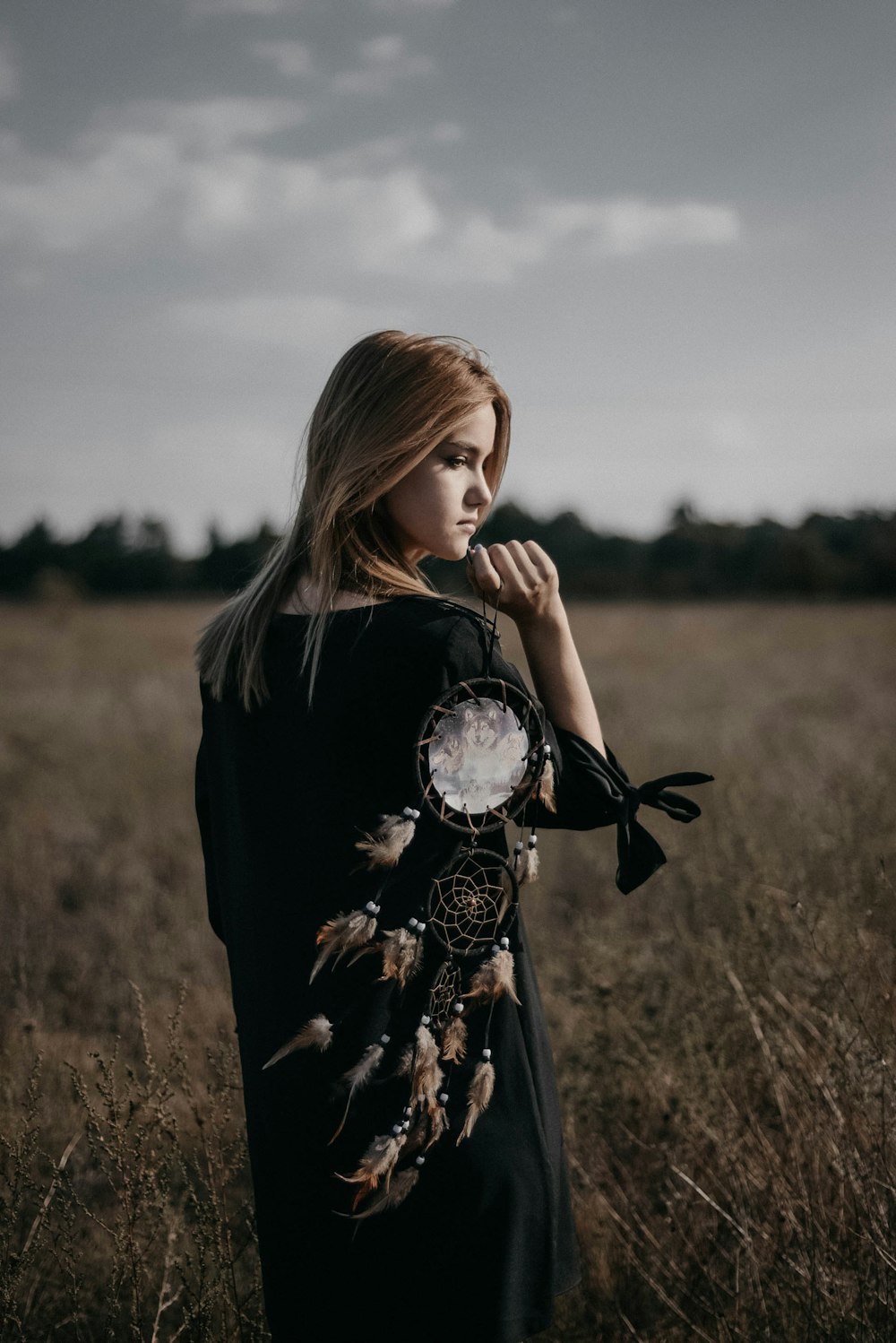 woman in black long sleeve shirt standing on brown grass field during daytime