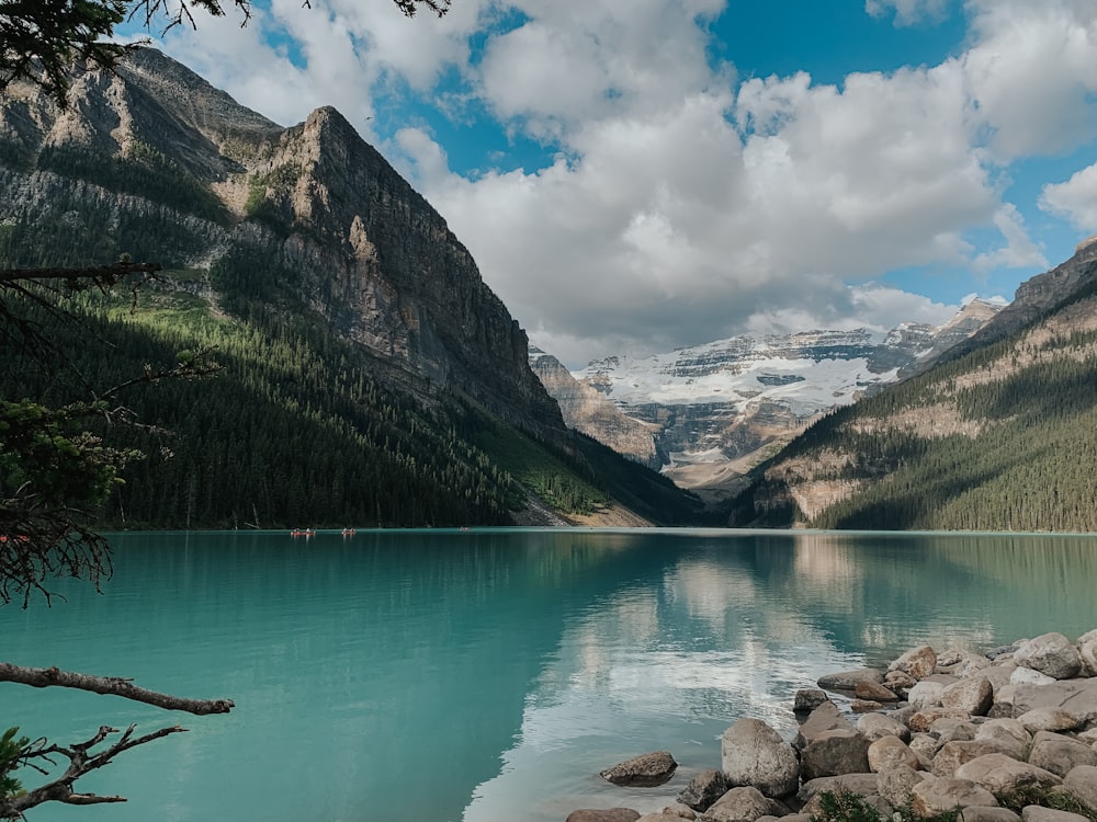 barco verde en el lago cerca de la montaña bajo el cielo azul durante el día