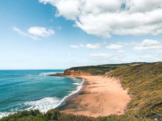 brown sand beach under blue sky and white clouds during daytime in Bells Beach Australia