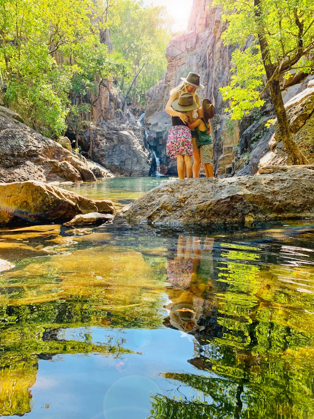 woman in black bikini standing on rock near river during daytime