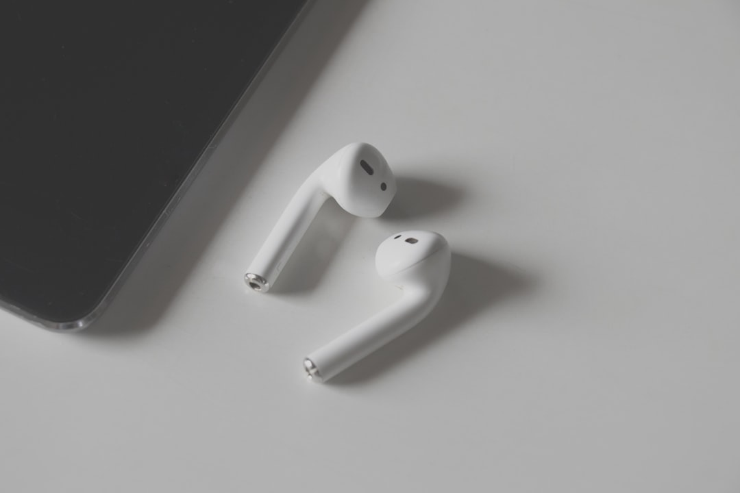 white apple earpods beside black smartphone