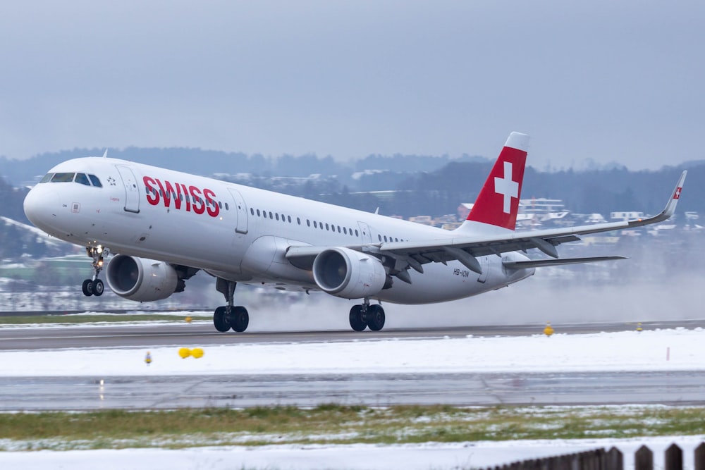 white and red passenger plane on airport during daytime