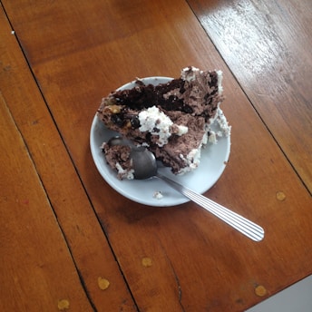 A slice of chocolate cake and apple pie served on a white plate with a fork