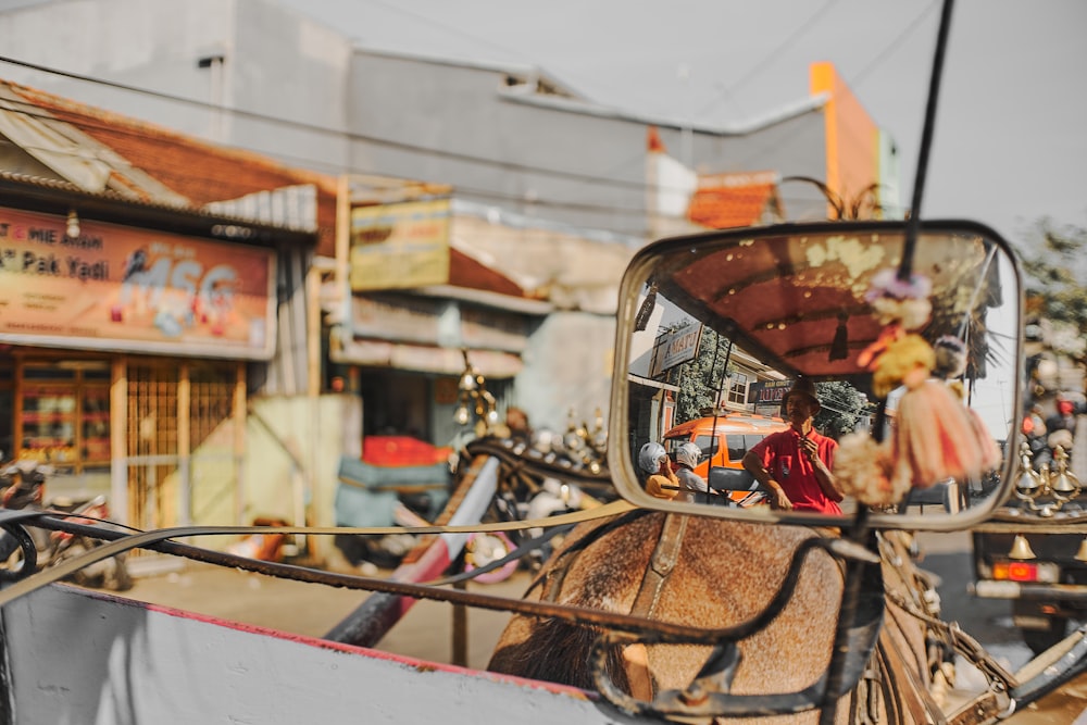 man in red jacket riding on black and brown horse carriage during daytime