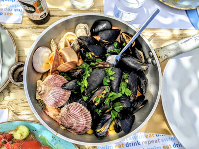 Assortment of fresh shellfish arranged on a rustic wooden table.