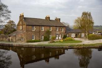 brown brick building near body of water during daytime