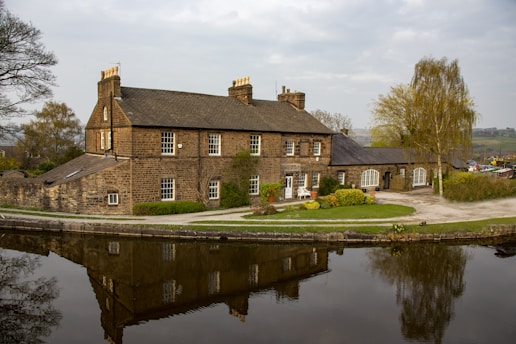 brown brick building near body of water during daytime