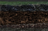 Close-up of soil layers exposed during a risk prevention survey.