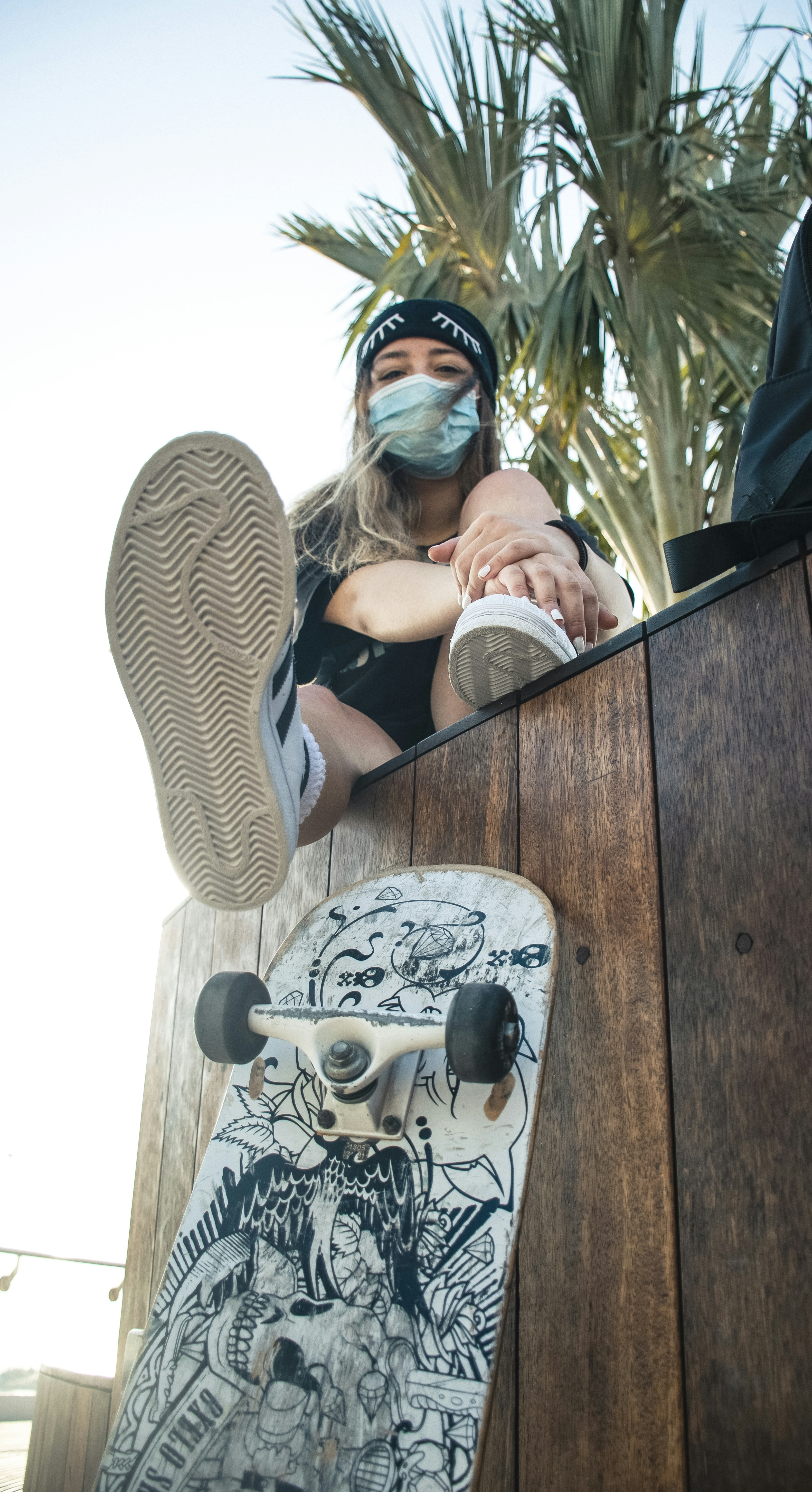 woman in white and black striped long sleeve shirt sitting on brown wooden chair