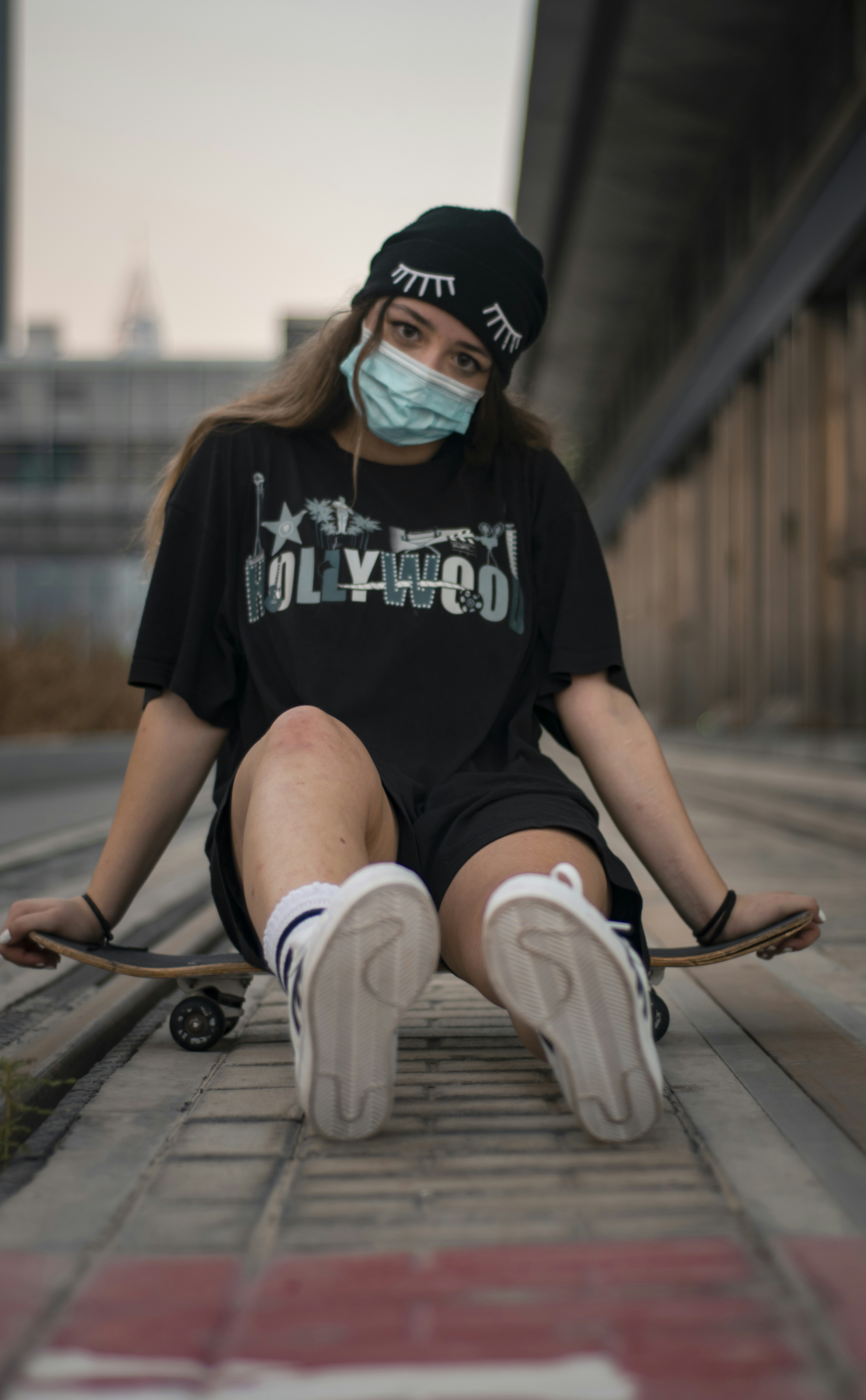 woman in black and white crew neck t-shirt and white pants sitting on brown wooden
