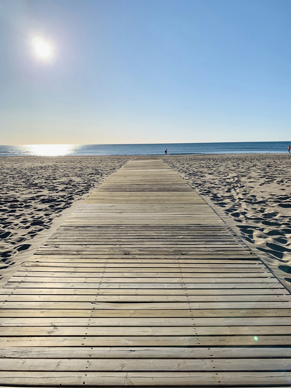 brown wooden dock on beach during daytime