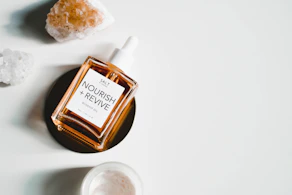A bottle of rich hair oil surrounded by fresh botanicals, highlighting nourishment and shine.