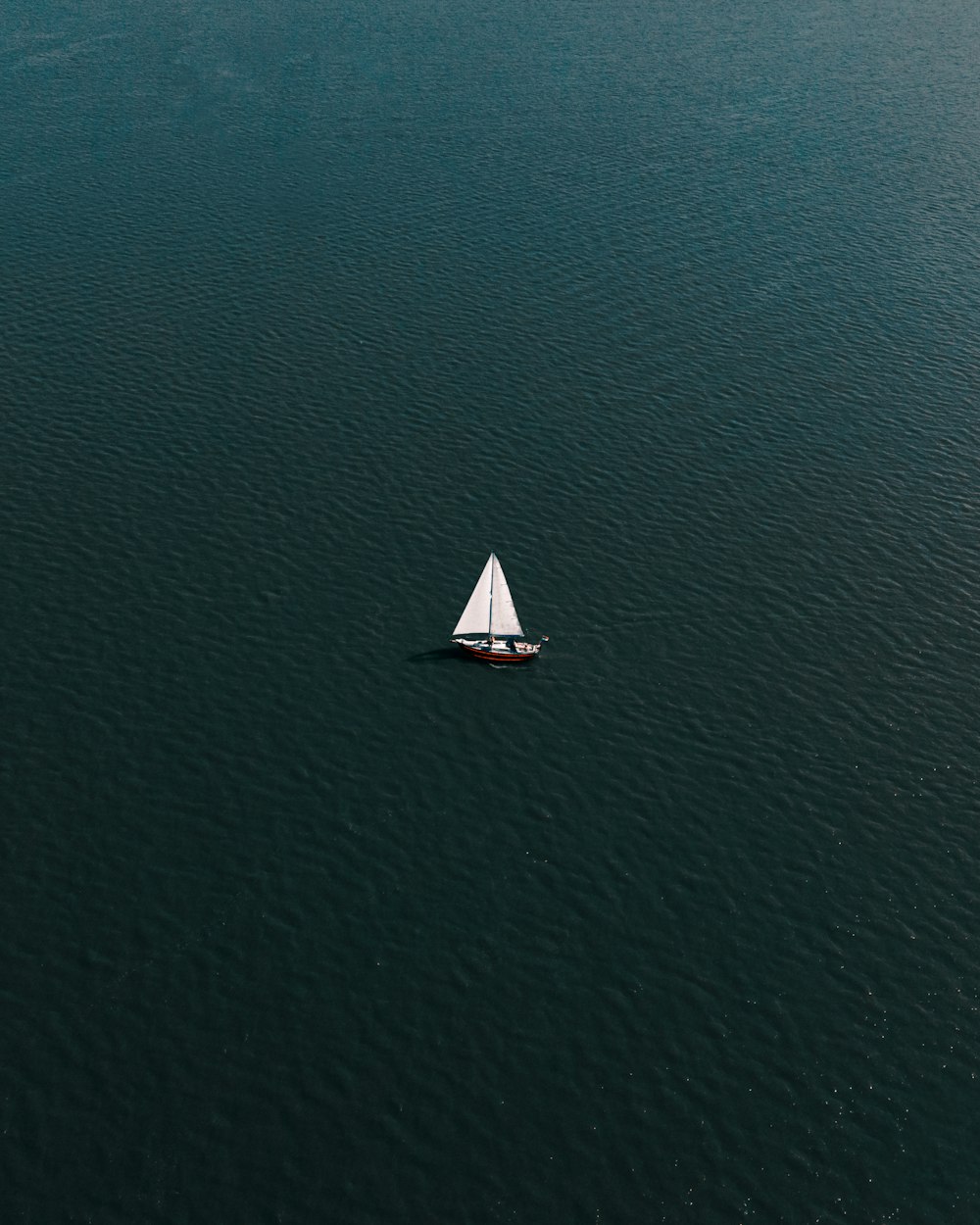 white sailboat on blue sea during daytime