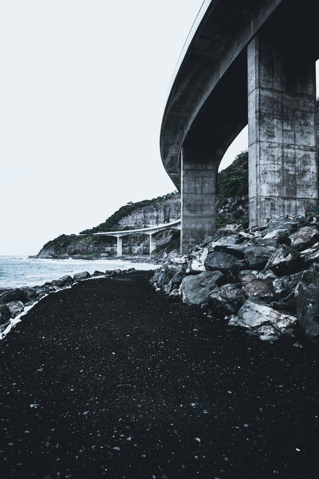 gray concrete bridge over the sea during daytime