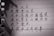 A close-up image of handwritten Chinese characters on lined paper with torn edges. The lighting casts shadows on the paper.