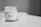 A white candle jar labeled 'THE RELATABLE CANDLE CO. No.6 WE BE CHILLIN' is placed on a white surface. The candle is lime, basil, and orange scented. There is a small cluster of white crystals on the left side.