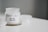 A white candle jar labeled 'THE RELATABLE CANDLE CO. No.6 WE BE CHILLIN' is placed on a white surface. The candle is lime, basil, and orange scented. There is a small cluster of white crystals on the left side.