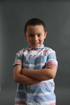 A young child confidently speaking on stage with a bright smile.