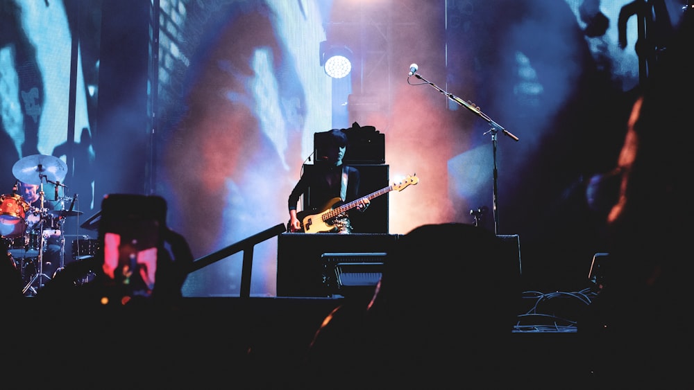 man playing guitar on stage