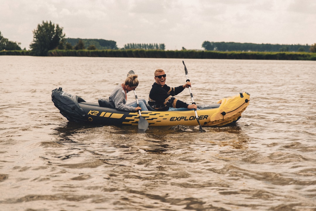 2 men and woman riding yellow kayak on river during daytime