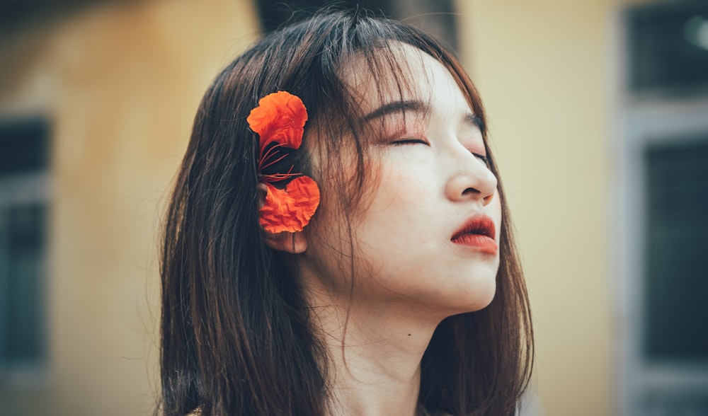 woman with red flower on her ear